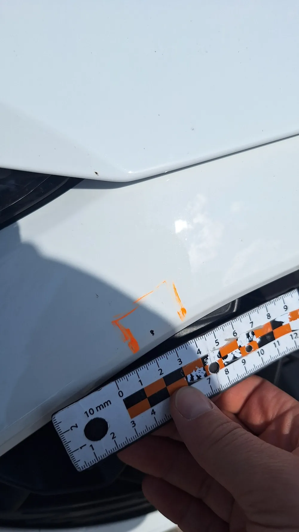 Zdjęcie SIXT: przedni zderzak z małym odpryskiem obrysowanym markerem i linijką